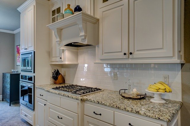 A close-up of newly painted white kitchen cabinets with granite countertops in Matthews.