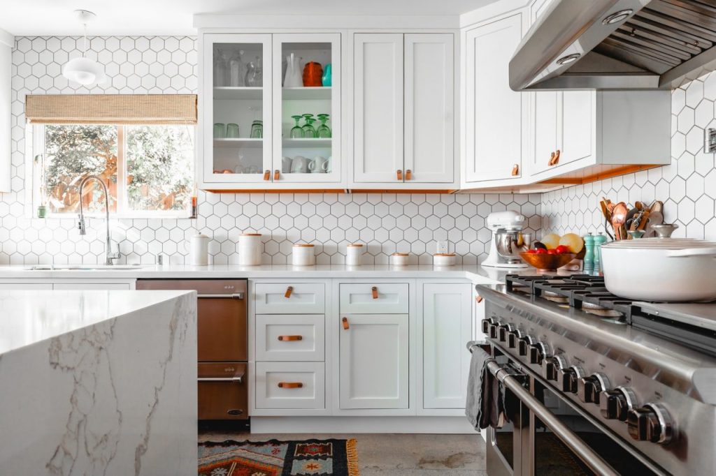 Expertly painted kitchen cabinets featuring white upper units and a grey island in Matthews.